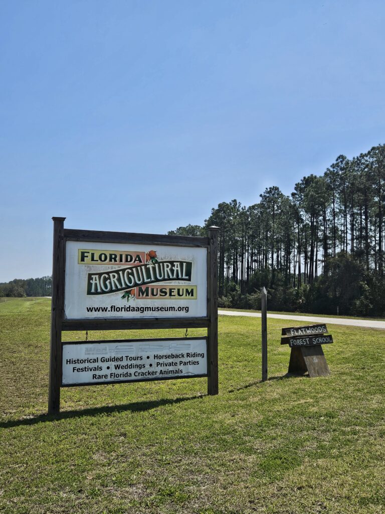 Sign for the Florida Agricultural Museum along a rural roadside with trees in the background