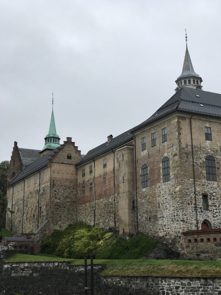 Exterior of Akershus Fortress with stone walls and towers in Oslo on a cloudy day