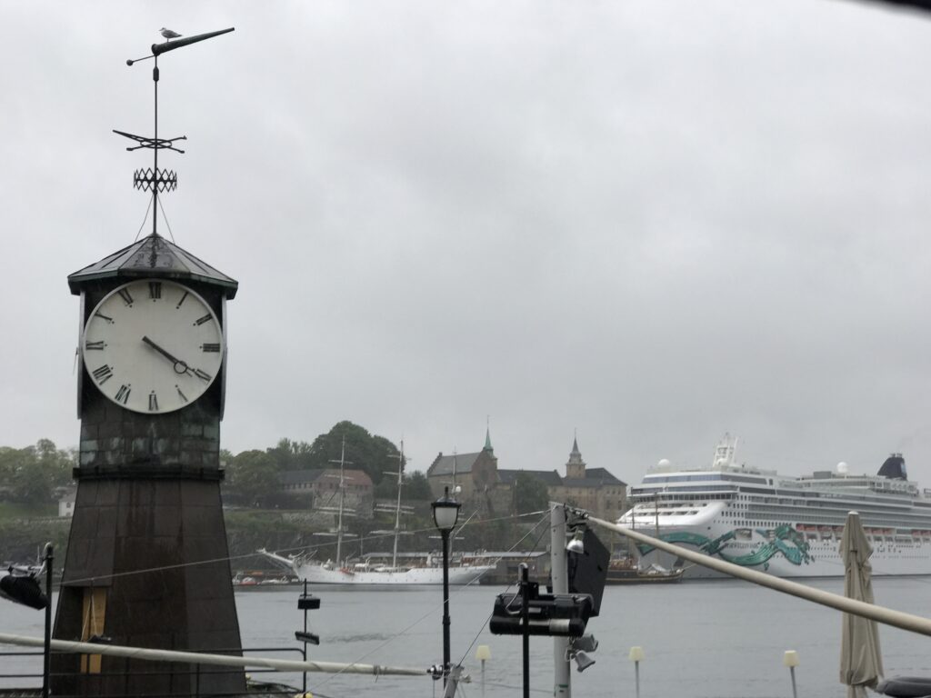 Clock tower overlooking Oslo harbor with cruise ship and city skyline in the background