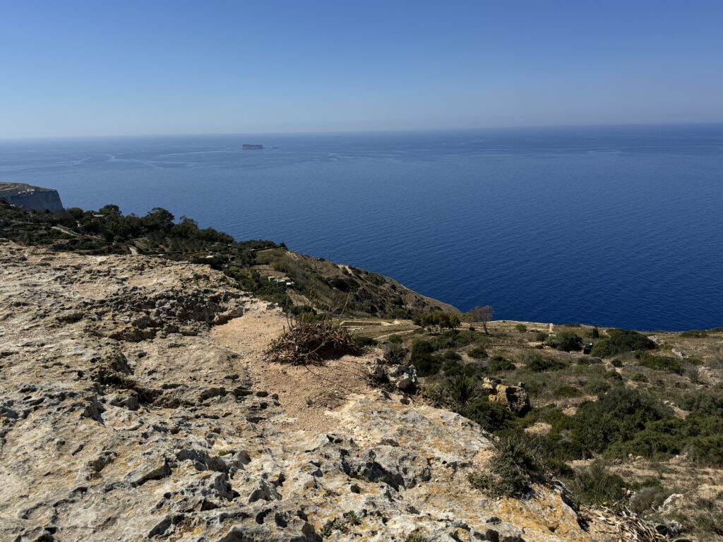 Rocky cliffside overlooking the deep blue Mediterranean Sea at Dingli Cliffs, Malta.