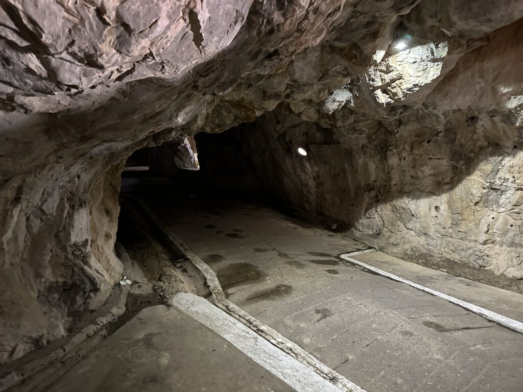 Underground tunnel corridor with curved rock ceiling inside the Gibraltar tunnel system.