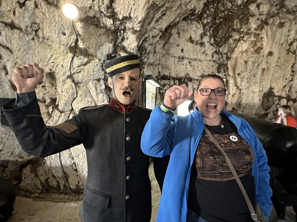 Visitors posing with a costumed guard inside the Great Siege Tunnels on the Rock of Gibraltar.