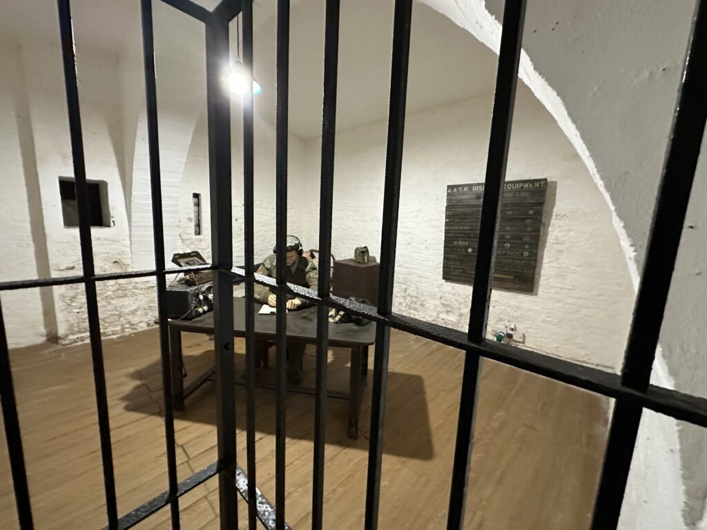 Interior room behind metal bars displaying historical artifacts inside the Great Siege Tunnels.
