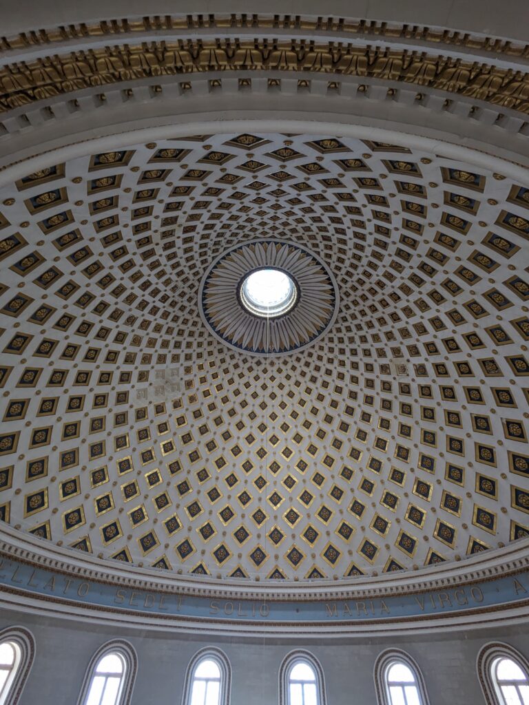 Ornate domed ceiling with geometric gold-and-blue pattern and central skylight above arched windows.