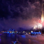 Colorful fireworks lighting up Hamburg’s harbor during Blue Port, with illuminated ships and buildings glowing blue along the water