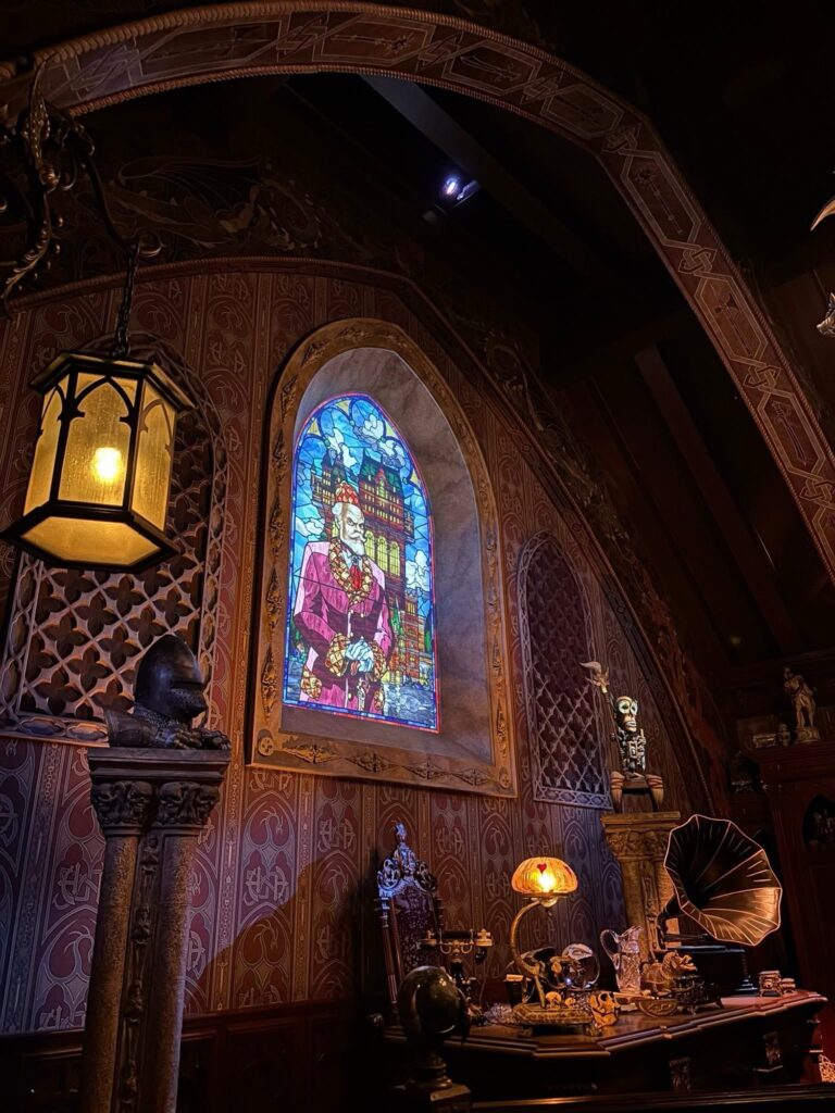 Interior themed room at Tokyo DisneySea with stained glass window, warm lighting, and detailed decor