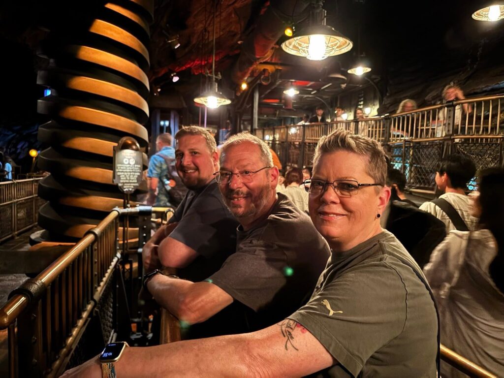 Guests waiting in line at Tokyo DisneySea attraction queue with warm lighting and detailed themed surroundings