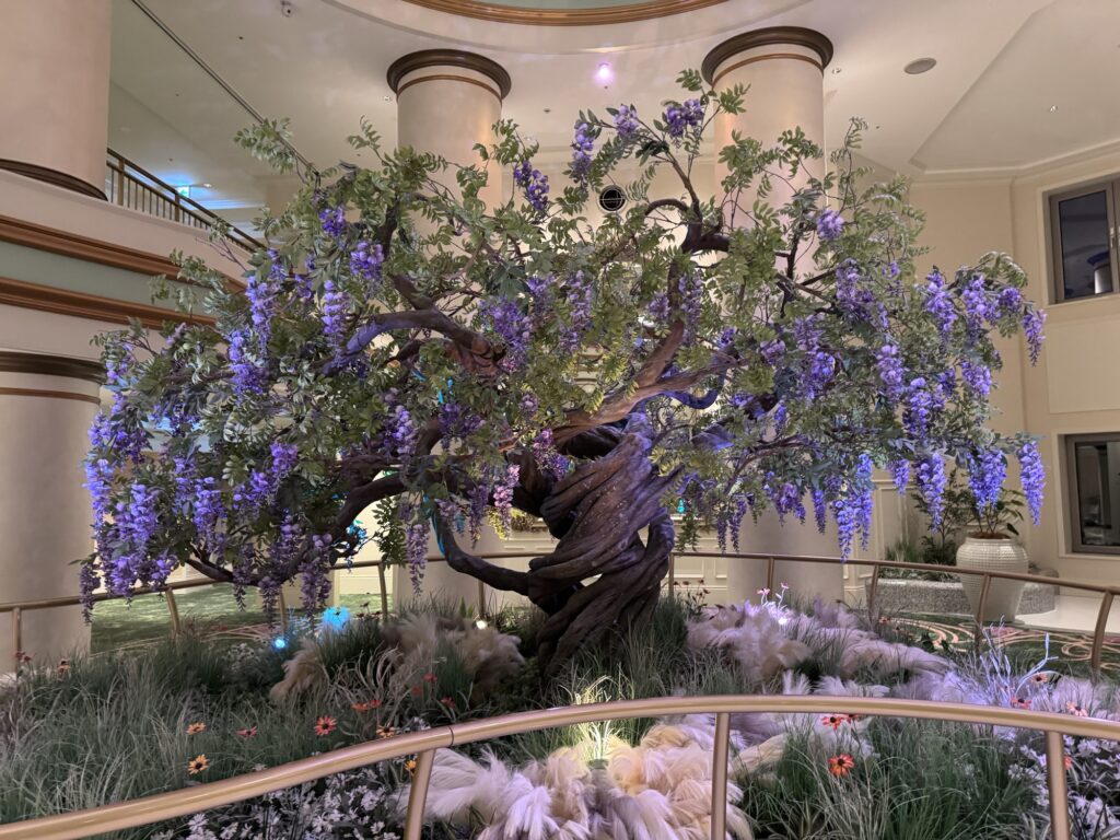 Decorative indoor tree with purple flowers inside Tokyo DisneySea’s Fantasy Springs Resort area