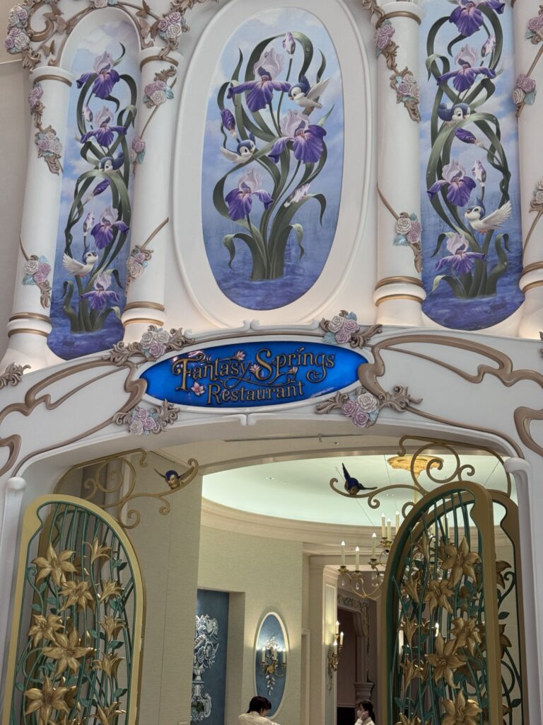 Entrance to Fantasy Springs restaurant at Tokyo DisneySea with floral murals and ornate pastel detailing