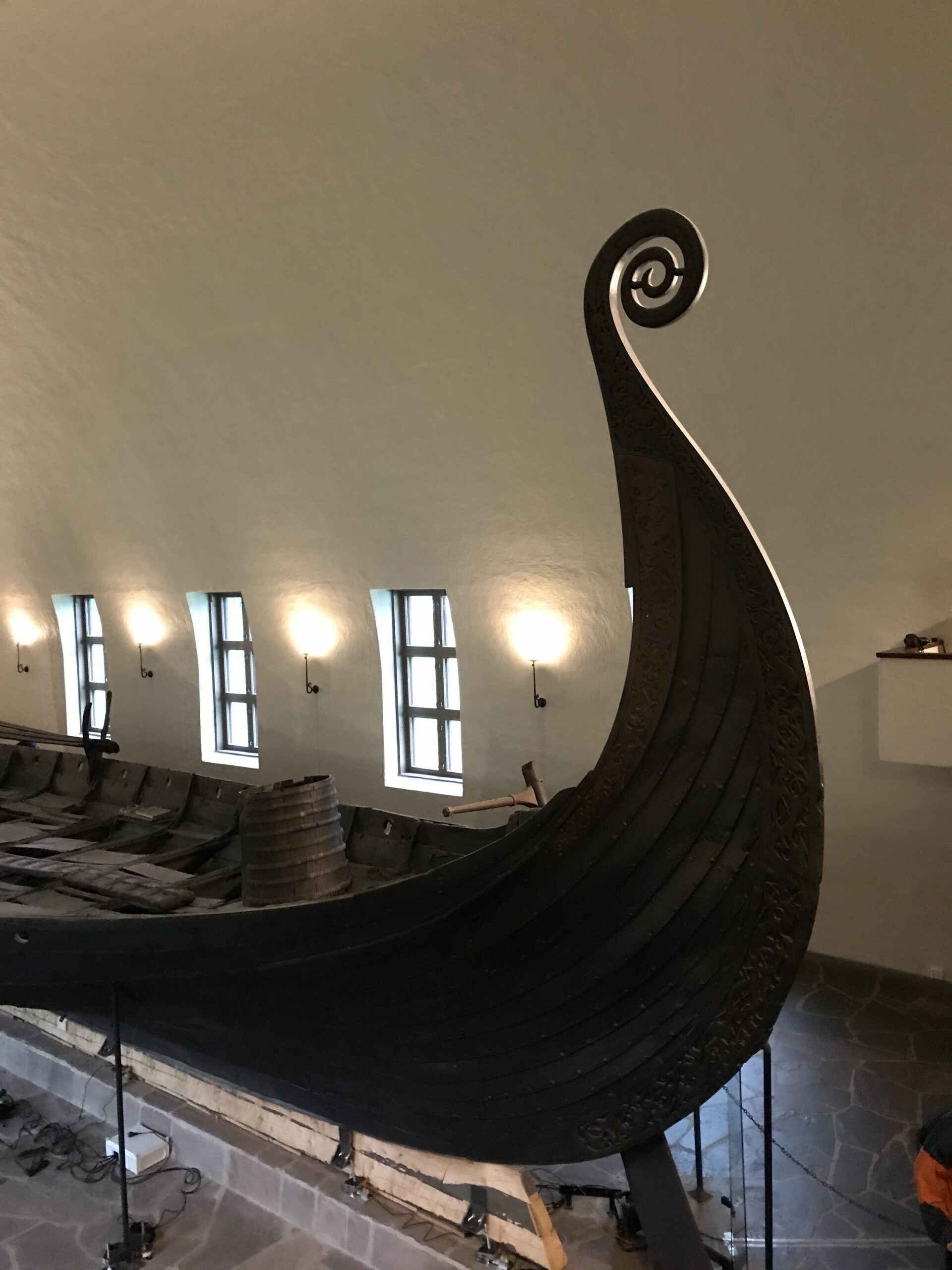 Close view of Viking ship prow with curved wooden design inside Oslo Viking Ship Museum