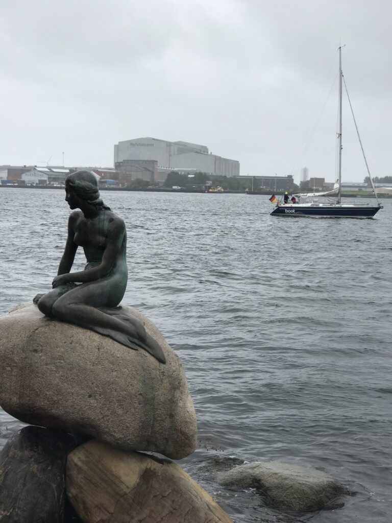 The Little Mermaid statue on a rainy day along Copenhagen harbor