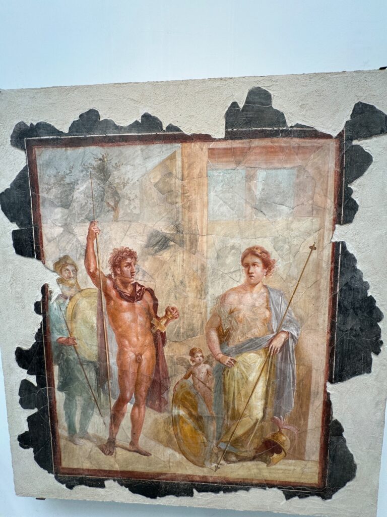 Ancient Roman fresco depicting mythological figures including a nude male warrior, a draped female figure, and cherubs in an architectural interior setting