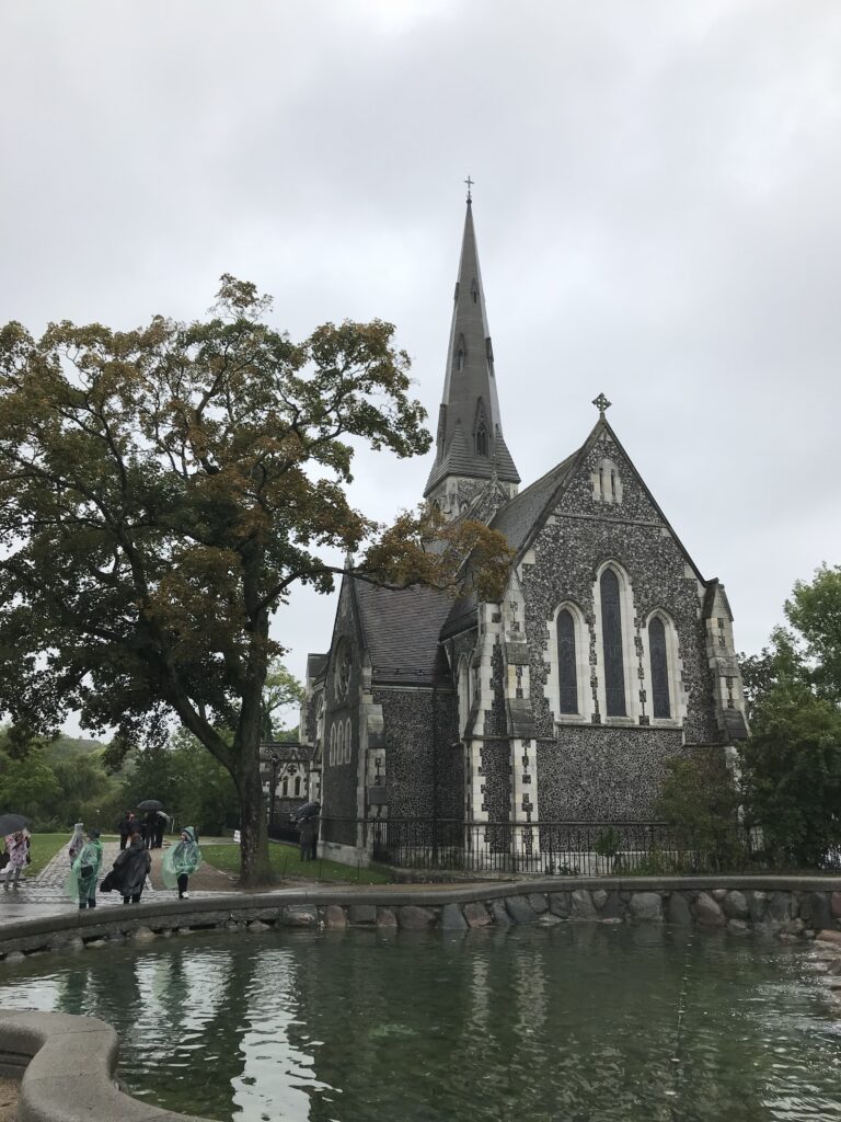 Church of Our Saviour area with historic stone church and people walking in the rain