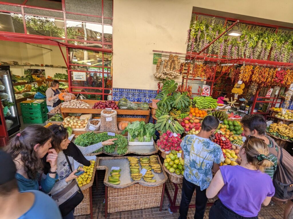 Visitors browsing fruit stalls inside Mercado dos Lavradores in Funchal Madeira