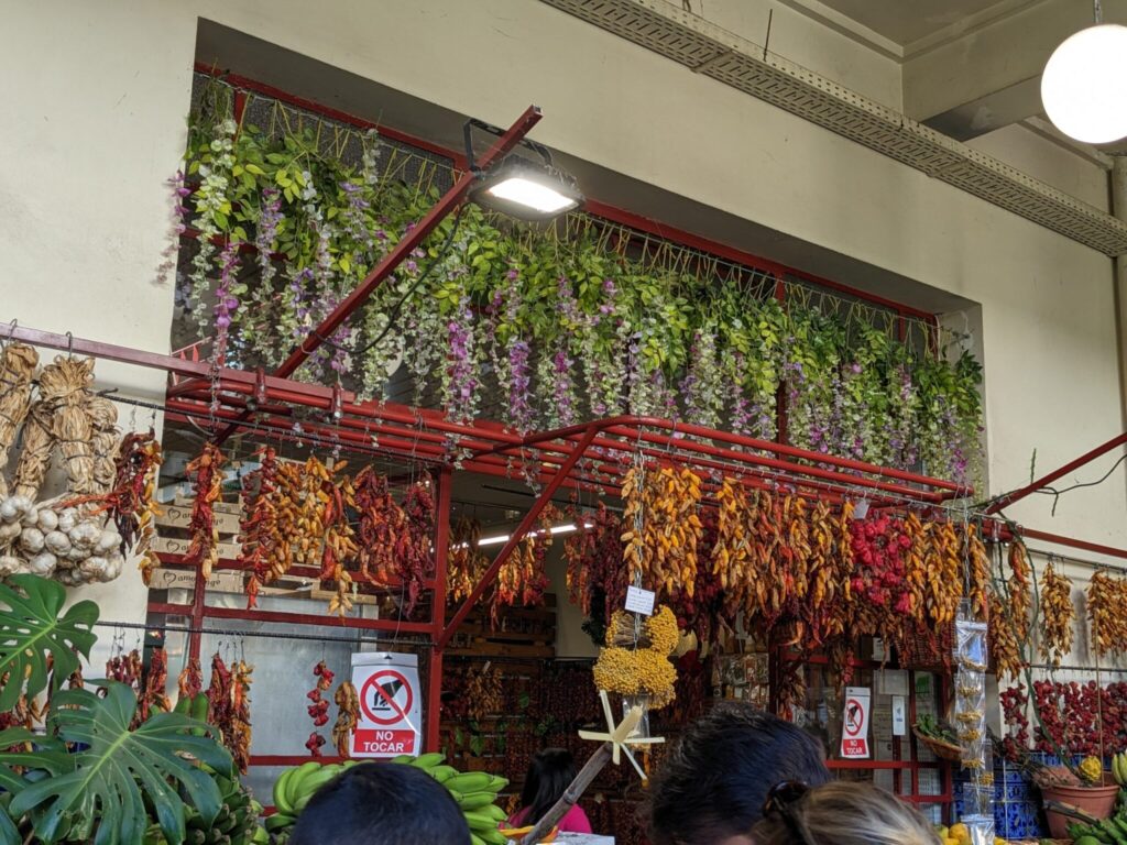 Hanging dried peppers and flowers inside Mercado dos Lavradores in Funchal Madeira