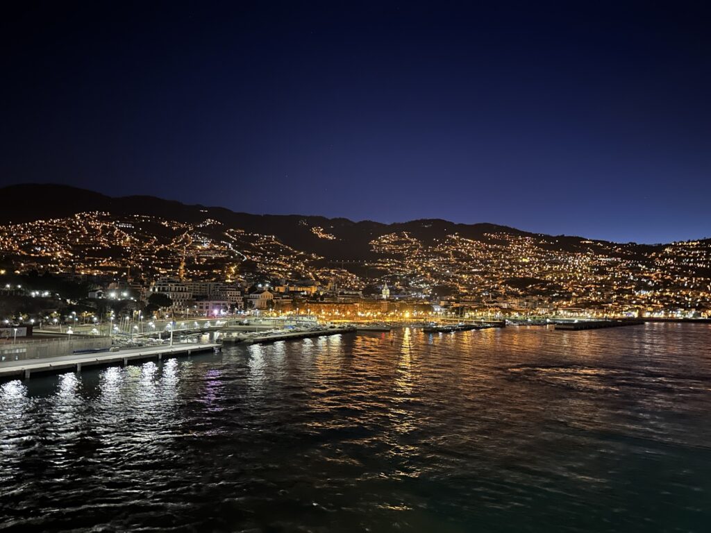 Early morning view of Funchal Madeira coastline with city lights reflecting on the ocean