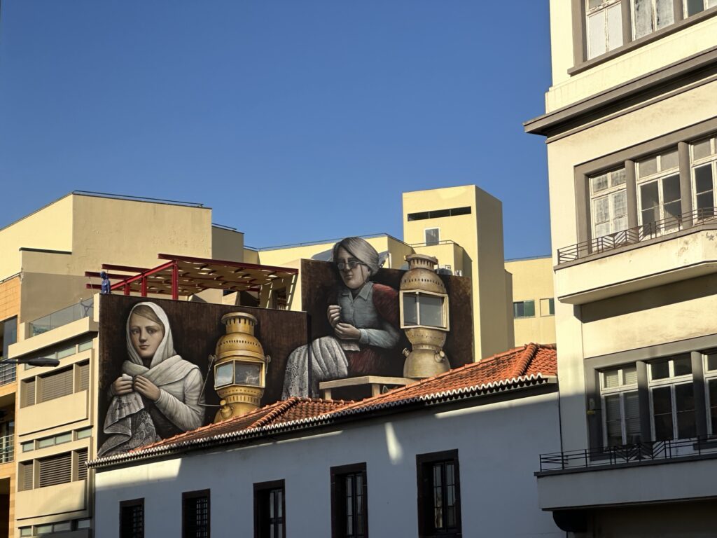 Colorful street mural on a building in Funchal Madeira featuring traditional figures and lanterns