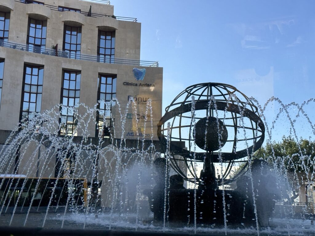 Fountain with globe sculpture in Funchal Madeira city center surrounded by buildings