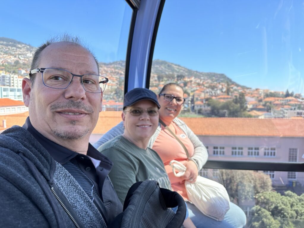 Passengers riding the Madeira cable car above Funchal with city views in the background