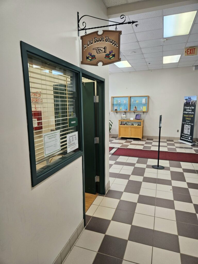 The Old Book Shoppe storefront with green door and window display in a mall corridor with checkered flooring