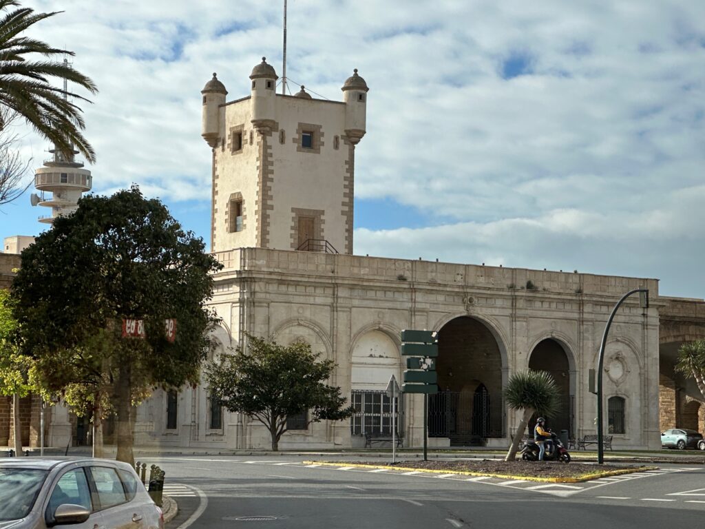 Historic fortified tower building with crenellations and arches in Mediterranean coastal town square