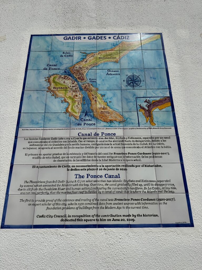 Decorative tile plaque mounted on a wall displaying a historical map of Cádiz, Spain, with information about the Ponce Canal in Spanish and English