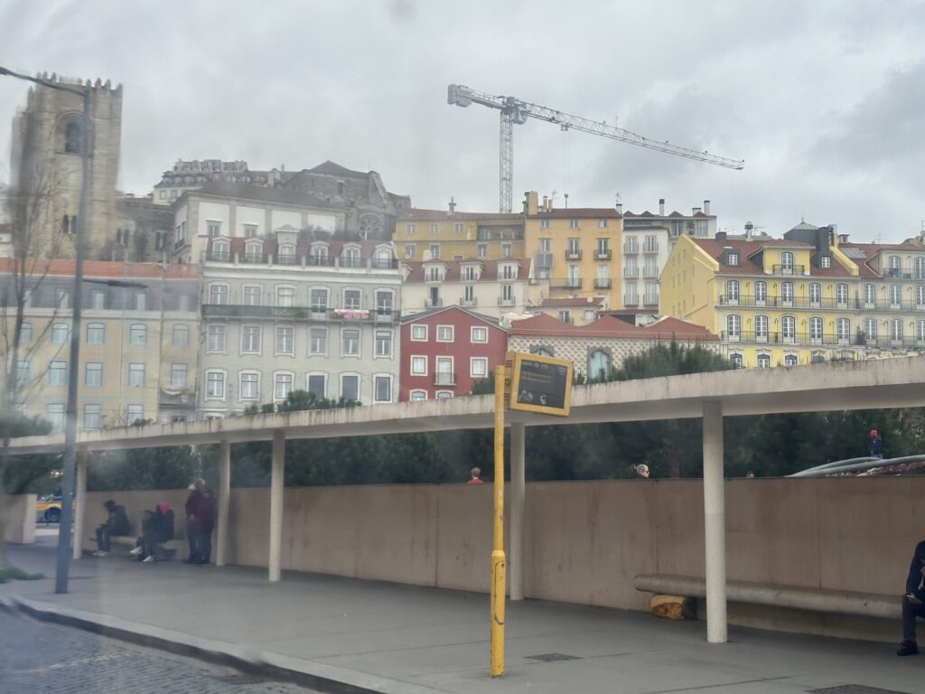 Colorful waterfront buildings in a European city with a concrete structure and construction crane overhead